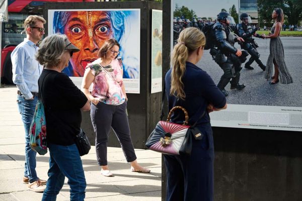 People visiting the Global Peace Photo Award exhibition on Madách Imre tér